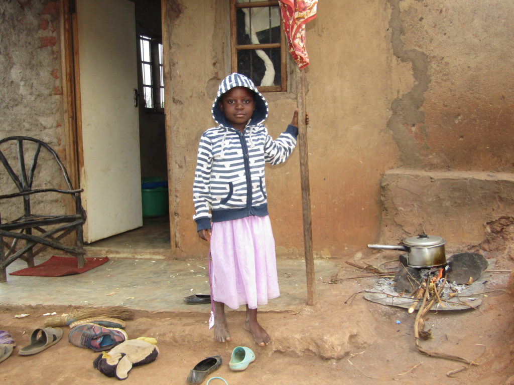 Glory in front of her house. Glory attends Life Child Moyo preschool in Malawi.