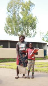 Janete and her mom standing in front of the Peace school in Mozambique